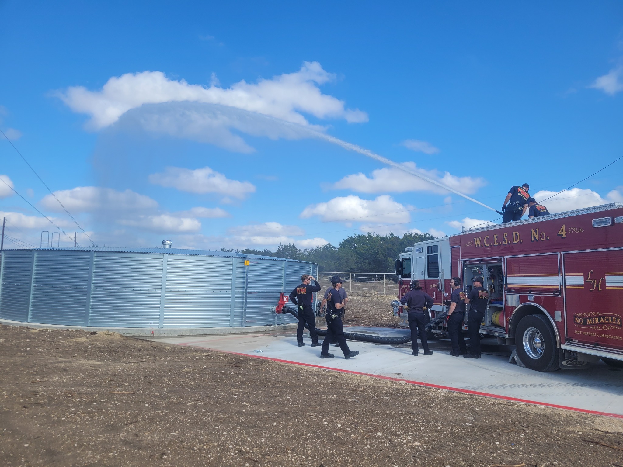 Firefighters testing a Freedom fire-water tank with a fire engine